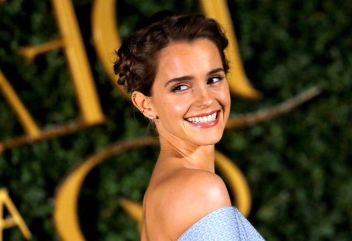 Emma Watson smiling for the camera at an award show.