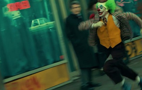 Arthur Fleck running from bullies and thugs in 2019 film Joker.