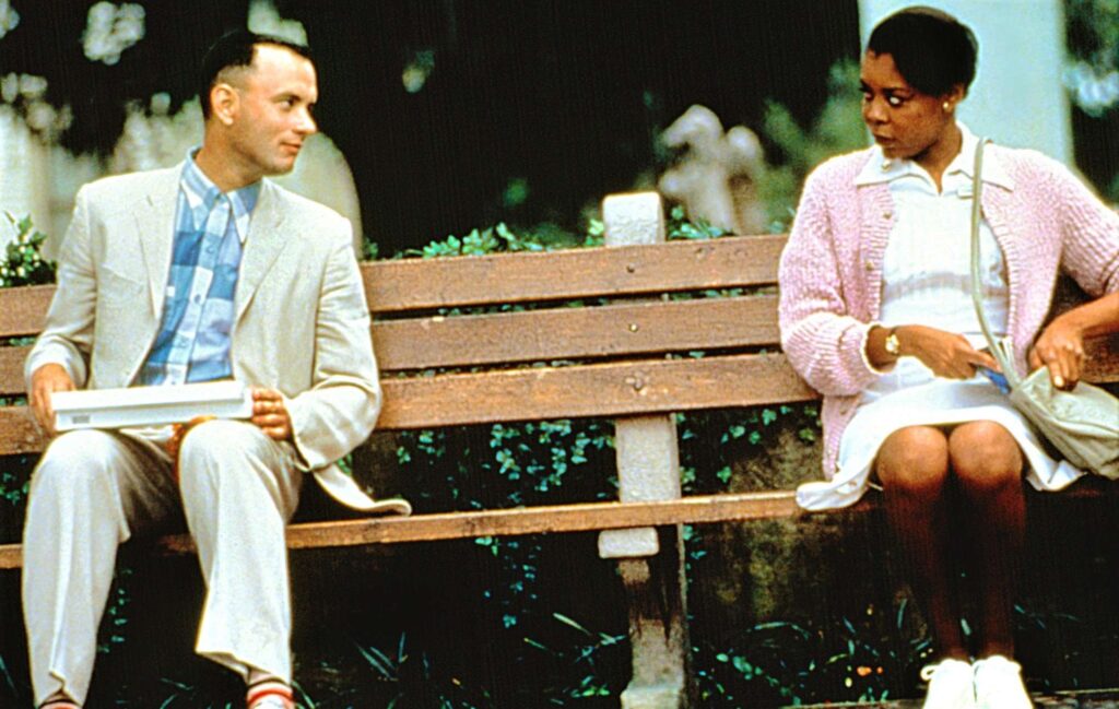 Tom Hanks sitting on the famous bench in romance drama film Forrest Gump (1994)