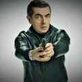 Rowan Atkinson holding a gun in the best funny/comedy film Johnny English.